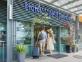 Para wchodzi do hotelu NAT Świnoujście z walizką i torbą.