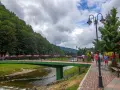 Most Szczawnicy z kwitnącym Grajcarkiem i spacerującymi ludźmi.