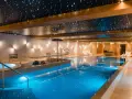 Basen w hotelu SPA z podświetlanym sufitem imitującym gwiazdy i błękitną wodą.