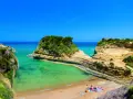 Malownicza zatoka z turkusową wodą, skalistymi klifami i piaszczystą plażą na Korfu.