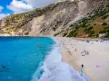 Widok z lotu ptaka na plażę Myrtos na Kefalonii z turkusową wodą i stromym klifem.