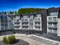Nowoczesny apartamentowiec z balkonami, otoczony lasem. Idealne miejsce na czarna góra noclegi.
