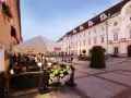 Taras restauracji z parasolami i kwiatami na tle zabytkowej kamienicy w Cieplicach.