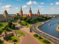 Widok na Szczecin z rzeką, budynkami i drogą z ruchem samochodowym.