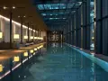 Nowoczesny basen hotelowy z przeszklonym dachem i oświetleniem, otoczony strefą relaksu.