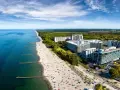 Widok z lotu ptaka na plażę nad Bałtykiem z hotelami i turystami.