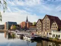 Bydgoszcz: rzeka, statki, zabytkowe kamienice i nowoczesna architektura.