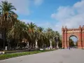 Łuk Triumfalny w Barcelonie z palmami i błękitnym niebem.