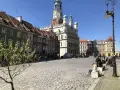 Rynek w Poznaniu z kolorowymi kamienicami i Ratuszem w tle.