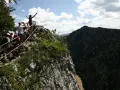 Grupa turystów na skalistym szczycie z widokiem na Pieniny i Dunajec.