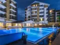 Nowoczesny hotel z basenem i leżakami wieczorem.