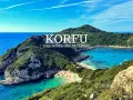 Widok na zatokę z turkusową wodą, plażą i zielonymi wzgórzami na Korfu.