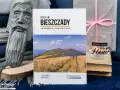 Drewniana rzeźba, książka o Bieszczadach, szklanka z napisem "Home" i prezent.