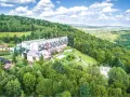 Hotel w otoczeniu zielonych lasów Gór Świętokrzyskich, z widokiem na dolinę.