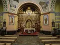 Wnętrze kościoła z ikonostasem, ołtarzem i ławkami.