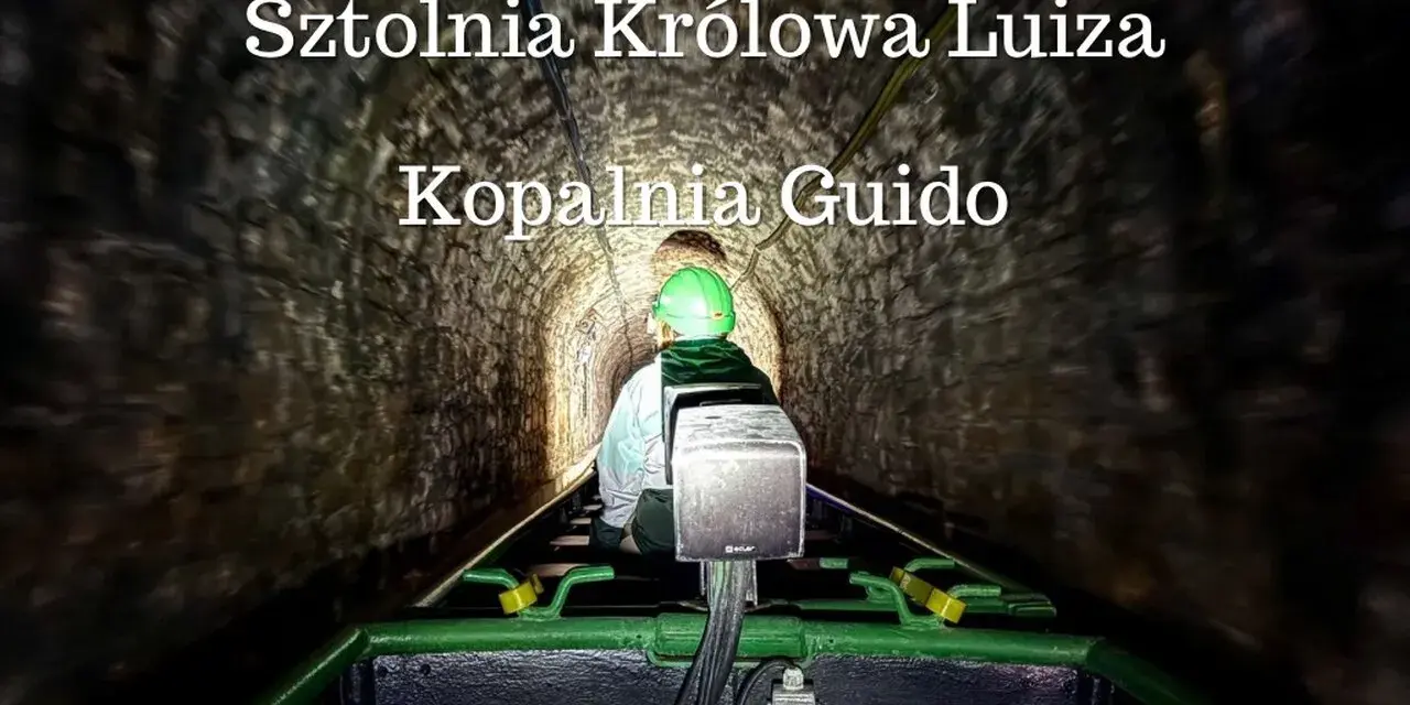 Osoba w kasku jedzie kolejką podziemną w sztolni.