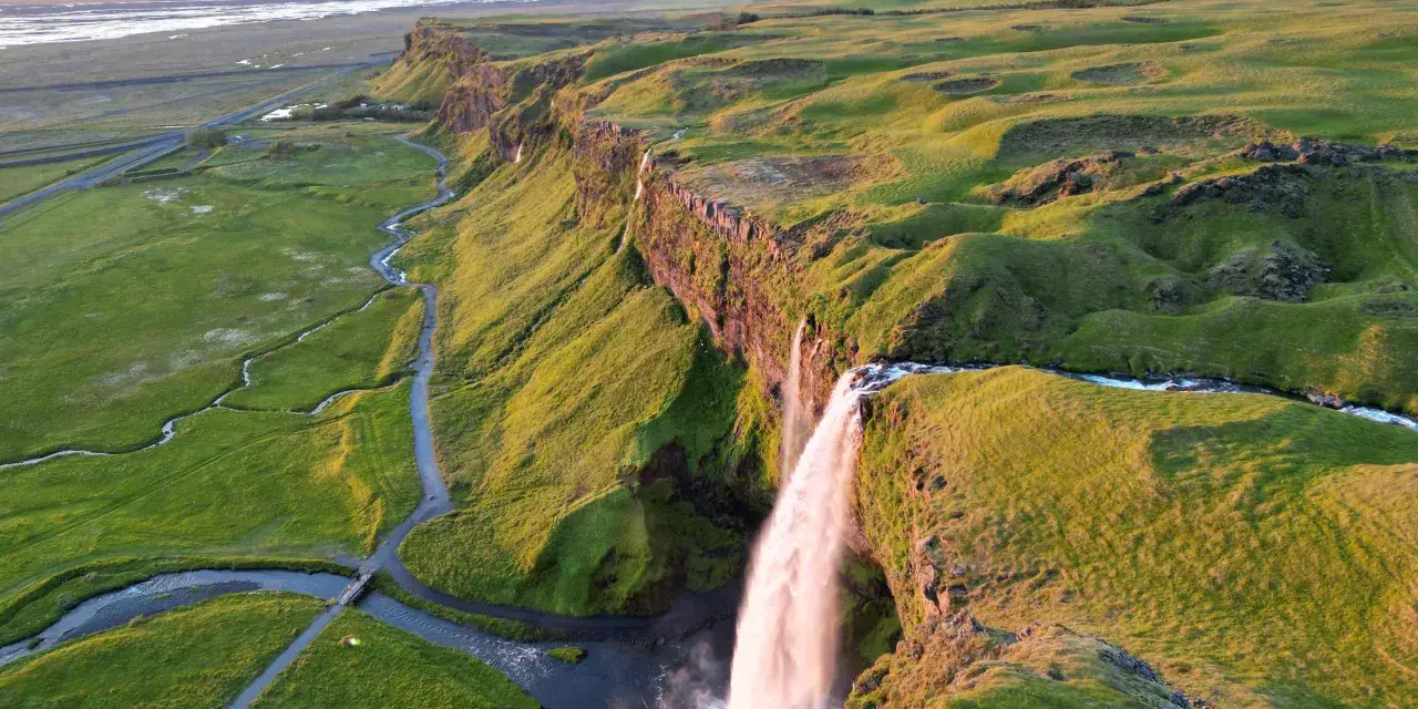 Wodospad Seljalandsfoss na Islandii w złotym świetle zachodzącego słońca.