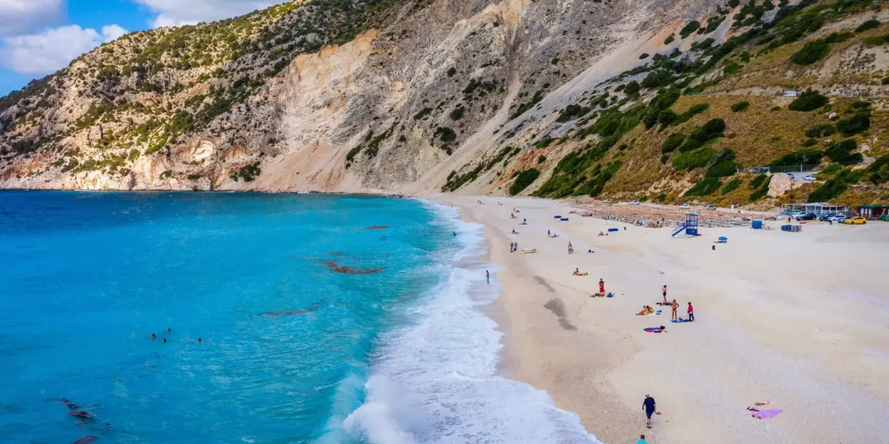 Widok z lotu ptaka na plażę Myrtos na Kefalonii z turkusową wodą i stromym klifem.