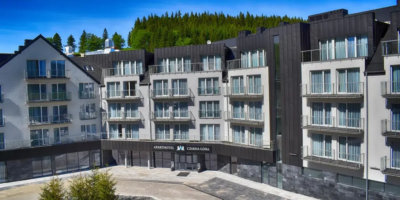 Nowoczesny apartamentowiec z balkonami, otoczony lasem. Idealne miejsce na czarna góra noclegi.