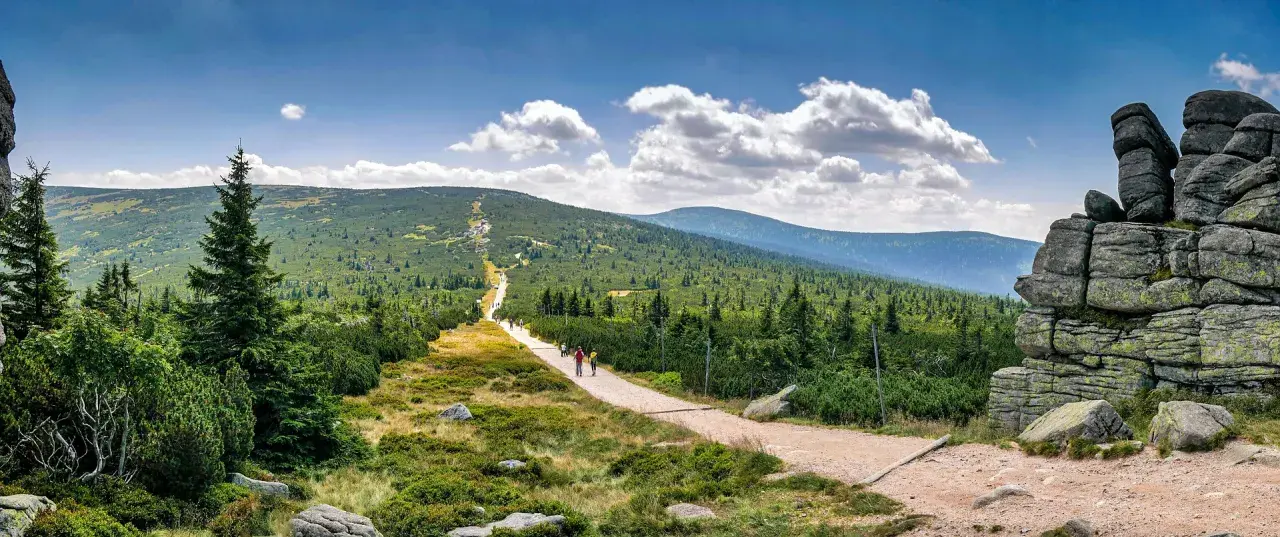 Kamieniste formacje skalne i szlak turystyczny w Karkonoszach.