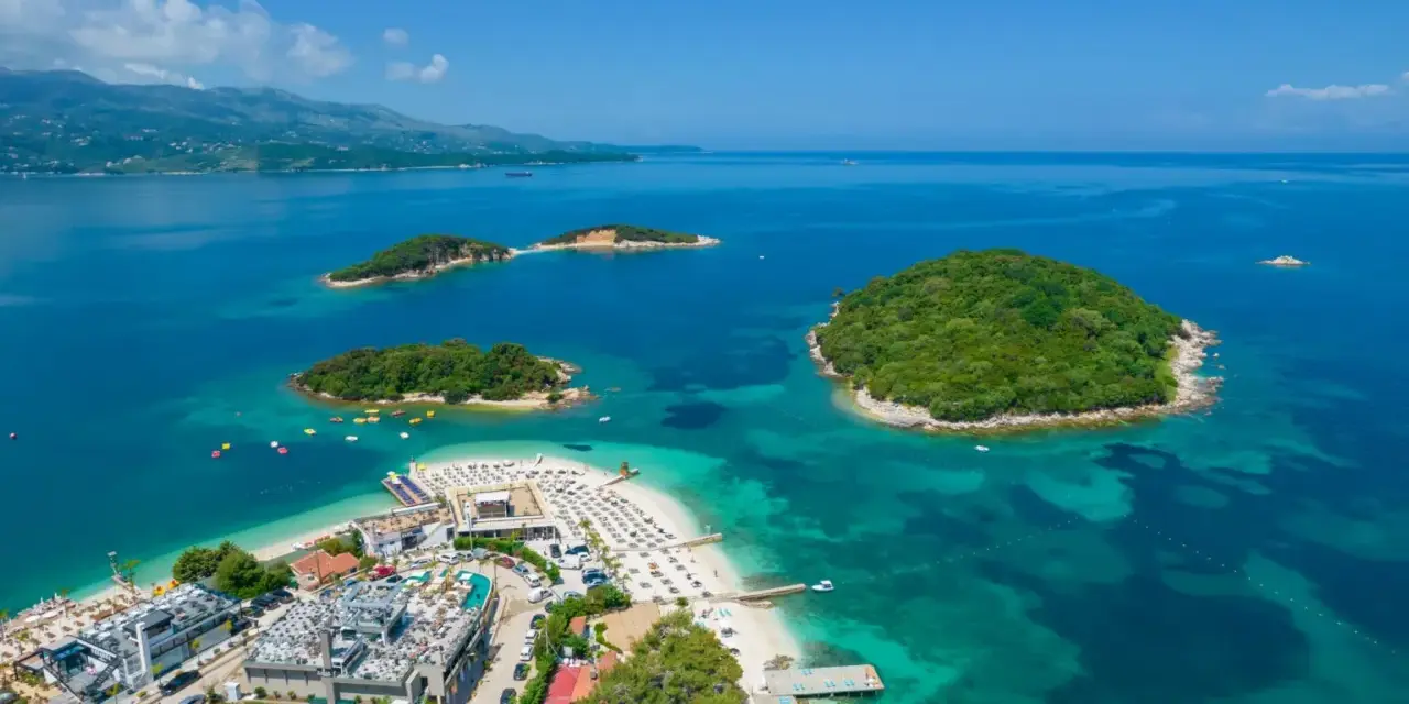 Widok z lotu ptaka na wyspy i plażę w Ksamilu, Albania, z turkusową wodą.