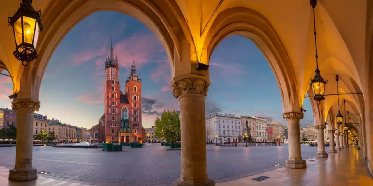 Sukiennice i Kościół Mariacki na Rynku Głównym w Krakowie o zachodzie słońca.