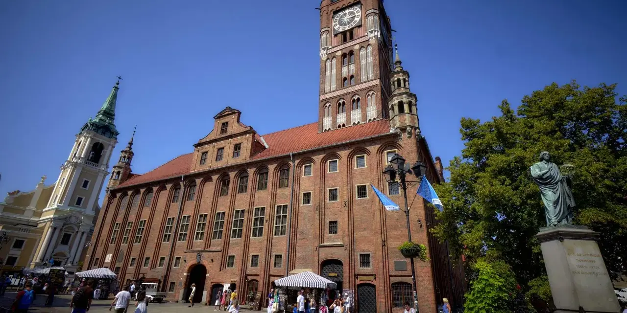Ratusz Staromiejski w Toruniu z wieżą zegarową i pomnikiem Kopernika na Rynku Staromiejskim.