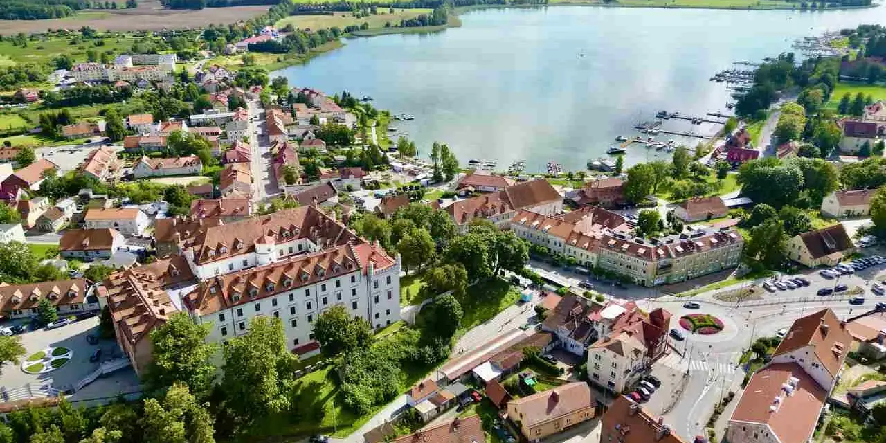 Widok z lotu ptaka na miasteczko nad jeziorem z zamkiem i mariną.