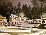 Architektura Szczawnicy nocą, ośnieżone budynki i drzewa, fontanna.