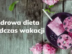Lody jagodowe na patyku i w kształcie krążków na talerzu, ozdobione kwiatami.