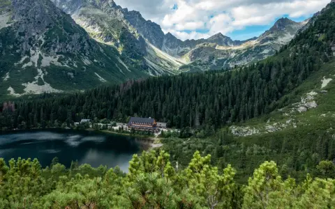 Popradzki Staw z hotelem i górami w tle.