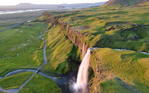 Wodospad Seljalandsfoss na Islandii w złotym świetle zachodzącego słońca.