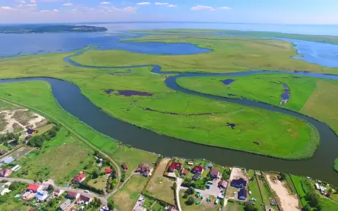 Krajobraz z lotu ptaka: zielone wyspy, meandrujące rzeki i zabudowania nad wodą.
