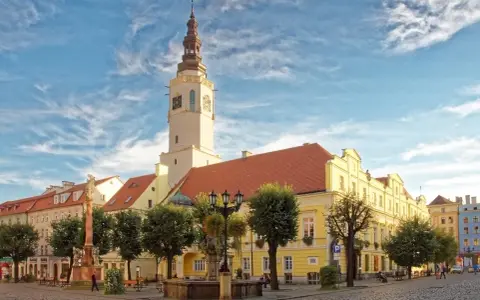 Rynek w Świdnicy z ratuszem, fontanną i zabytkowymi kamienicami.