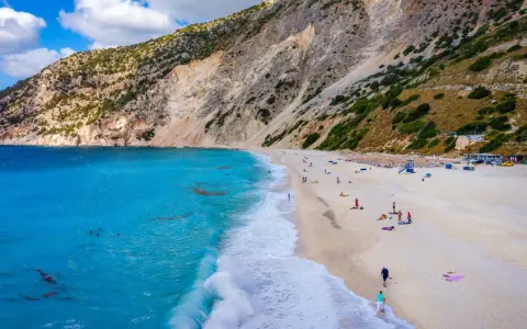 Widok z lotu ptaka na plażę Myrtos na Kefalonii z turkusową wodą i stromym klifem.