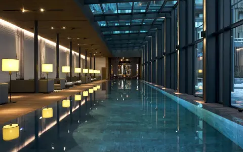 Nowoczesny basen w hotelu SPA z przeszklonym dachem i oświetleniem.