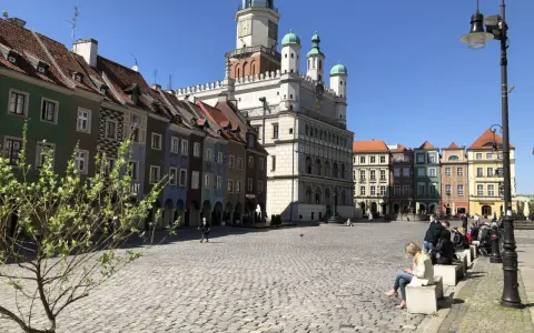 Rynek w Poznaniu z kolorowymi kamienicami i Ratuszem w tle.