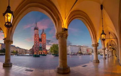 Sukiennice i Kościół Mariacki na Rynku Głównym w Krakowie o zachodzie słońca.