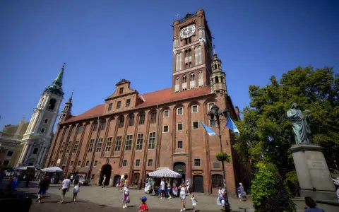 Ratusz Staromiejski w Toruniu z wieżą zegarową i pomnikiem Kopernika na Rynku Staromiejskim.