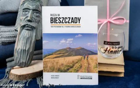 Drewniana rzeźba, książka o Bieszczadach, szklanka z napisem "Home" i prezent.