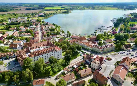 Widok z lotu ptaka na miasteczko nad jeziorem z zamkiem i mariną.