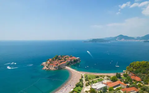 Wyspa Sveti Stefan w Czarnogórze z plażą i turkusowym morzem.
