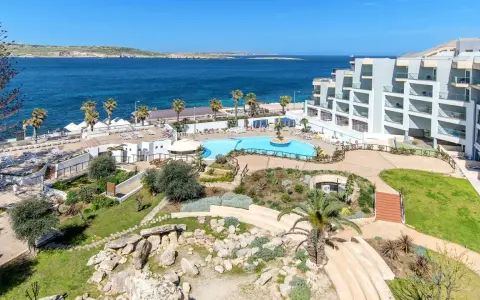Widok na hotel z basenem i morzem na Malcie.