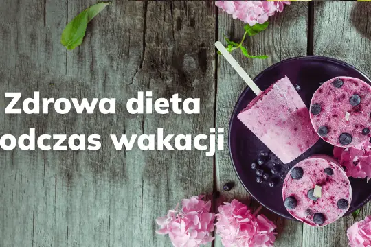 Lody jagodowe na patyku i w kształcie krążków na talerzu, ozdobione kwiatami.