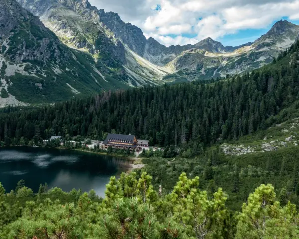 Popradzki Staw z hotelem i górami w tle.