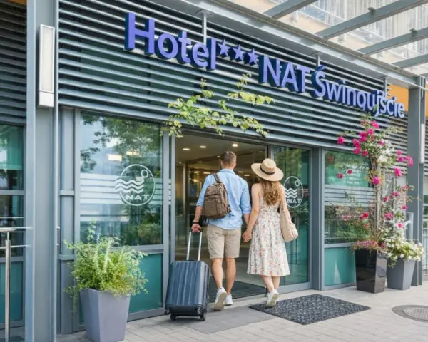 Para wchodzi do hotelu NAT Świnoujście z walizką i torbą.