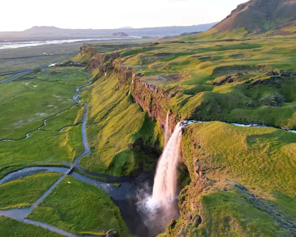 Wodospad Seljalandsfoss na Islandii w złotym świetle zachodzącego słońca.