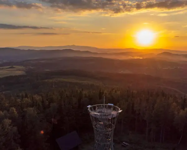 Wieża widokowa na tle zachodzącego słońca nad Górami Stołowymi.