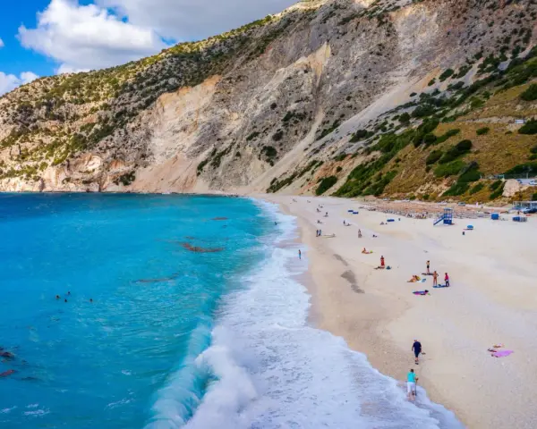 Widok z lotu ptaka na plażę Myrtos na Kefalonii z turkusową wodą i stromym klifem.