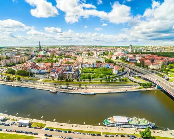 Widok z lotu ptaka na Szczecin z rzeką, nabrzeżem, statkami i mostem.
